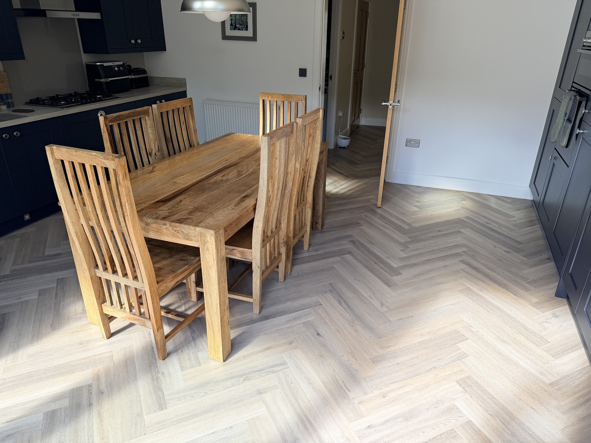 A completed patterned floor through a dining room and kitchen